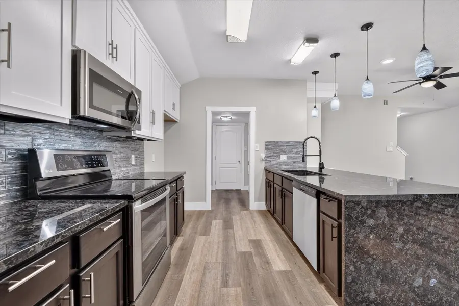 Kitchen with a stainless range, dishwasher, tile backsplash, and dark base cabinets at 716 River Hill Ln