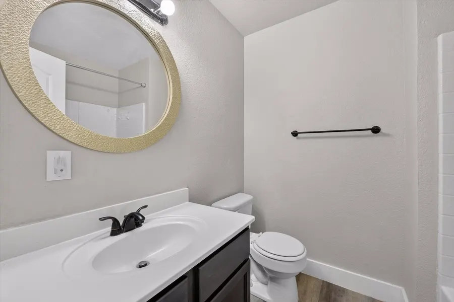 Bathroom with a round framed mirror, vanity, and tub at 716 River Hill Ln